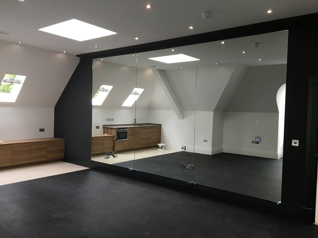Frameless glass wall dividing loft conversion in Southgate